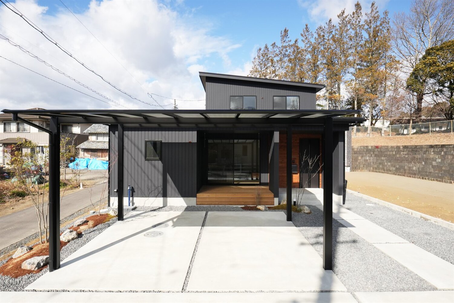 豊田市の北欧ナチュラルな注文住宅｜カーポートと外構が仕上がった黒ガルバリウムの外観