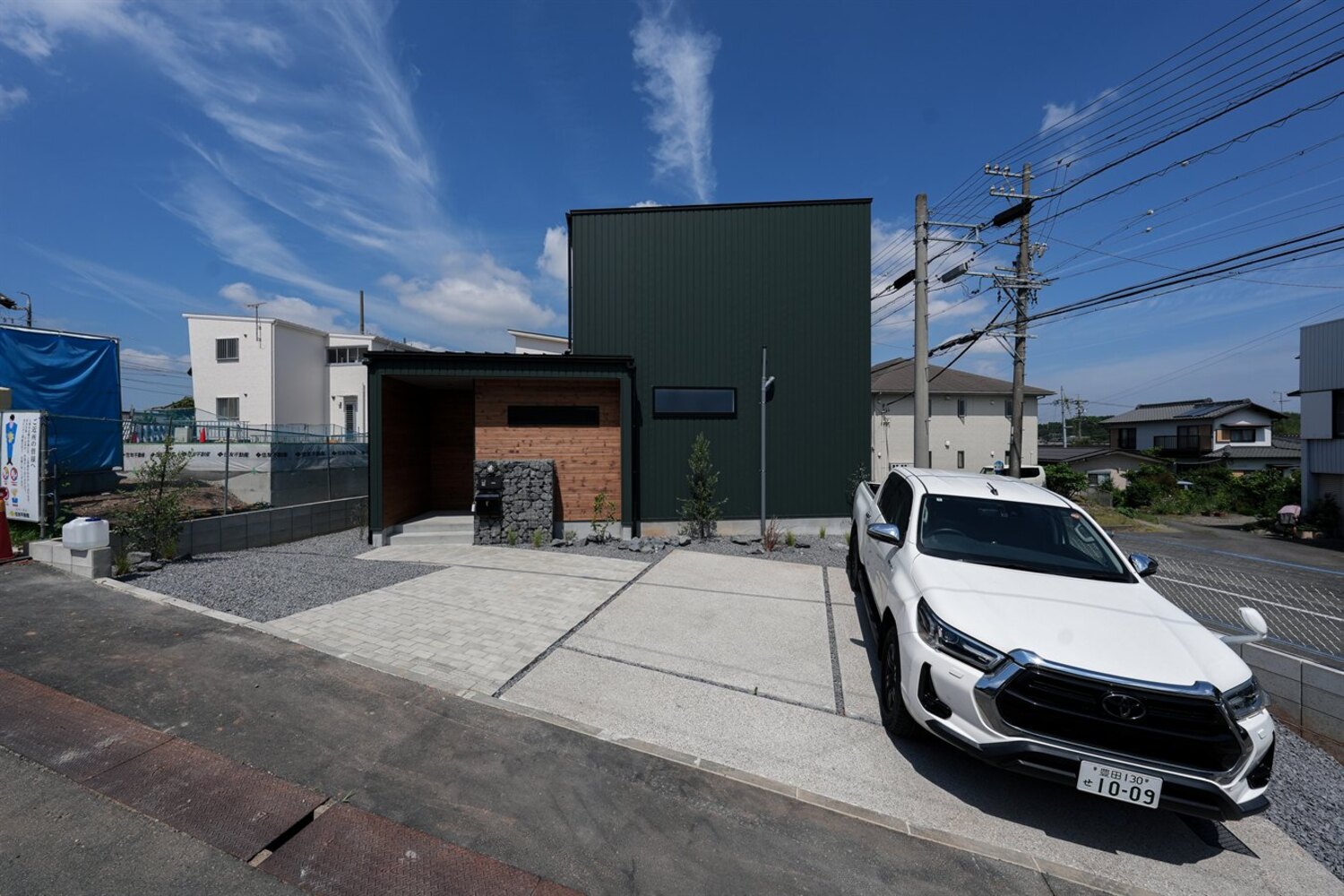 黒ガルバリウムの箱型外観と木・ガビオンの外構｜大府市吉田町の家