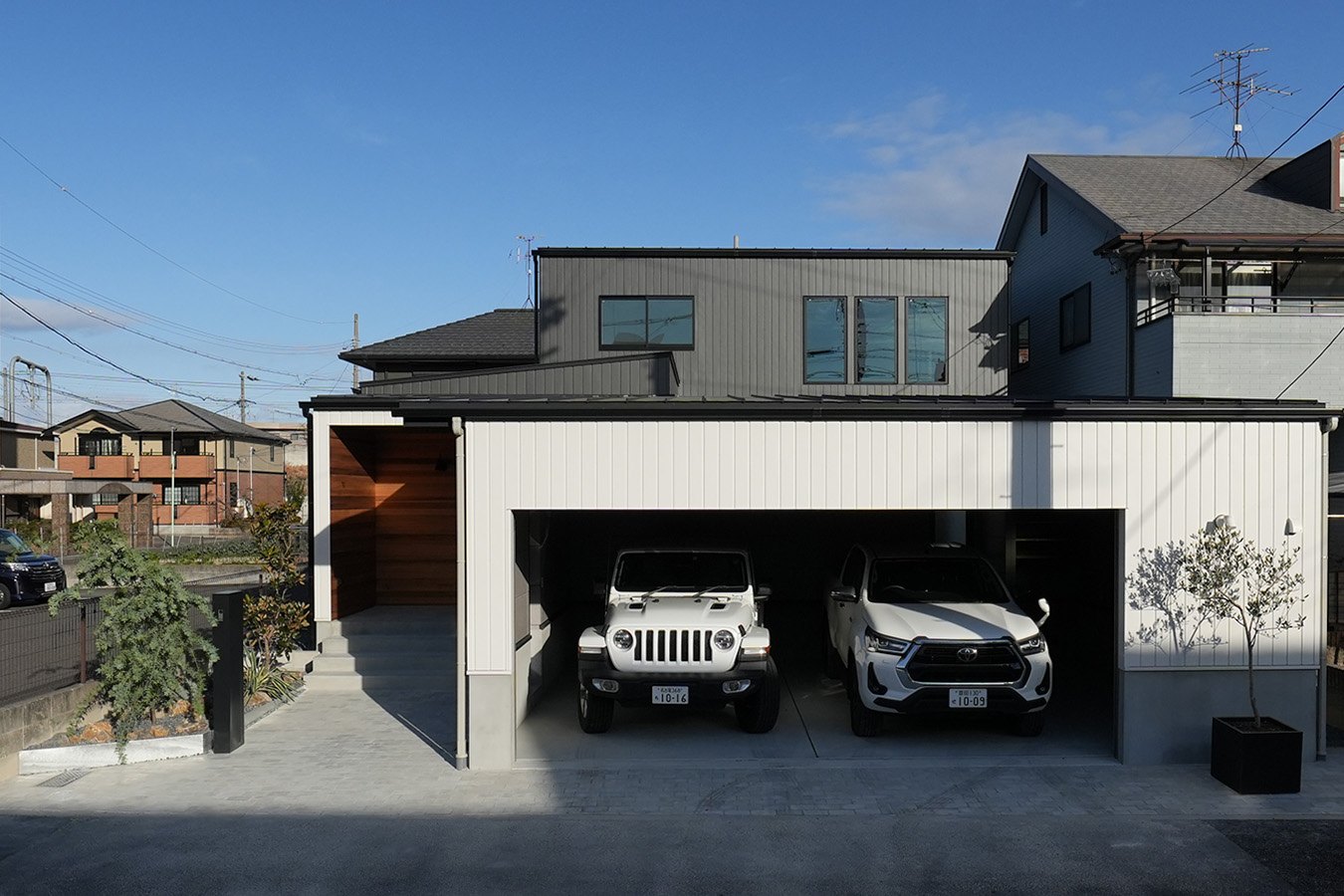 車2台分のビルトインガレージがある注文住宅の外観。ガレージの上は下屋、その奥に一回り小さい2階が載る部分2階の構成